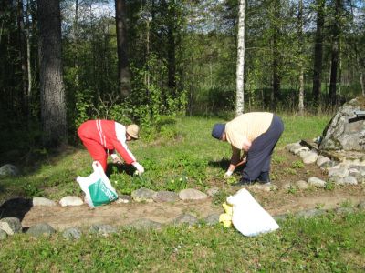 Sankarihautausmaan kunnostus menossa. 
Lahdenpohjalainen tulkimme Muusa (vas) kitkee kukkapenkkiä.  
