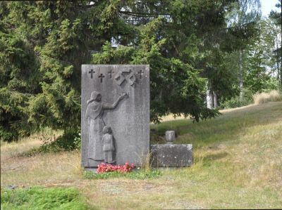 KUHMOINEN
Päijänteen pohjoisosassa, tuon suuren järven länsirannalla on Kuhmoinen, joka vuoden 2021 alusta vaihtoi maakuntaa Keski-Suomesta Pirkanmaahan.
Luovutettu Karjala-sivuston pitäjäliite tietää kertoa, että Kuhmoisiin asettui viitisensataa valkjärveläistä. He ottivat 1960-luvun alkupuolella asiakseen muistokiven pystyttämisen. Tämä kirkon viereiseen rinteeseen sijoittuva kivi on harvinaisen koskettava, eikä vähiten luonnollisen miljöönsä takia. Minun on helppo nähdä siinä mummoni ja isäni, joka oli viimeisen evakkomatkan alkaessa 9-vuotias.

"Karjalan kumpujen kätköissä nukkuvien muistolle."

Matalaan sivukiveen on nakuteltu teksti:
"Kuhmoisten karjalaiset pystyttivät 1963 tämän muistomerkin muistoksi jälkipolville."

Harmillista, ettei teoksen veistäjä selvinnyt. Kuka ikinä hän onkin, hänen kädenjälkensä koskettaa katsojaa.

Lähde ja lupa: FB-sivusto Evakkojen muistomerkit, Markku Ilari Manninen
