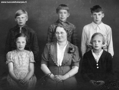 Multamäen koulun 6 luokan päättäjäispäivänä otettu kuva 1937. Ylärivissä vas. Ahti Salminen, Sakari Paukkunen, Olli Karvinen, alarivissä vas. Esteri Siitama, opettaja Rauha Hakanen ja Hilkka Pessi.
