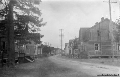 Koiviston Makslahden keskustaa vuonna 1934.  Vasemmalla ison männnyn takana kansanrunouden kerääjä Ulla Mannosen kotitalo seuraavaksi Soinisen matkustajakoti sekä Parkkalin kahvila-ravintola. Oikealla Taimi Valjakan sekatavarakauppa, Viipurin Osuuliikkeen myymälä sekä Senja, Irja ja Arvi Kouhian kotialo. Nykyisin paikalla on venäläisiä kolmikerroksisia kerrostaloja.    
