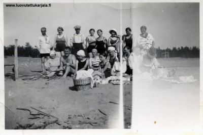 Muurilan hietikolla Suomenlahden rannalla. Ed. istuu vas. Mari Muurinen, Matti Laukkanen, Kyllikki M, Hilja Laukkanen, Raili Laukkanen, ?, Simo Ahokas, Seisoo: Herman?, ?, Nikodeemus M, Terttu M, Anna-Liisa Ahokas, Helka Ahokas, Kaija M ja Helena Ahokas.  
