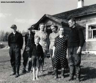 Kurkijoen Sorjoon muutti viime vuosisadan lopulla nälkää pakoon Pohjanmaan ruotsalaisperheitä joiden jälkeläisiä asuu kylässä vieläkin ja jälleen evakkomatkan jälkeen. Kuvassa Emil Björklundin perhe kotinsa edustalla. Emil isäntä äärinmäisenä. Kesäkuu 1941. Julkaisuoikeus vain pääesikunnan kevakeskuksen luvalla. Käytettävä tekstiä SA-kuva (151947) 
