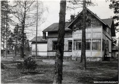 Kuvassa lukee: Talvihuvila 1 1/2 ha maa-ala Lounatjoella. Johannes Räikköläinen Kurkijoki Alppimaja.  Eri käsialalla on kirjoitettu: Talvisodan perääntymisretkellä 1940 löydetty kuva.
