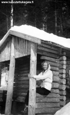 Lumivaaran Oinaanvaara kauniin Hepolammen rantatörmmään sotilaiden rakentama hirsisauna. Terasssilla poseeraa Aune  Nenonen. 
