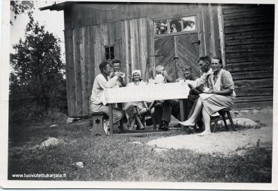 Heinätalkoot Perkjärvellä 1939. Vasemmalta talon väki Jooseppi, Erkki, Hilja ja Anja (näkyy pöydän alta) Paloposki. Eino Kultanen (kannun takana) Uuno, Vihtori ja Siiri Kultanen. Eino Kultanen kaatui talviodan viimeisinä päivinä 8.3.1940. Kuvasi Väinö Viipuri  
