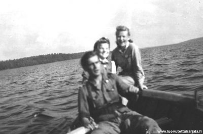 Soutamassa Kiimajärvellä, takan näkyy Suursaari. Kuvassa edessä olevan sotilaan nimi ei ole tiedossa. Keskellä Elna Äijö ja takana Varpu Pöyry. Kuvattu muistin mukaan n 20.06.1944   
