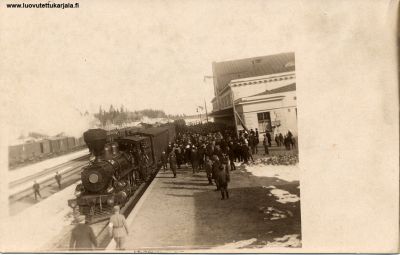 Kuvassa lukee: 1 juna Raudun asemalla. Kuvassa vuosiluku 1915. 
