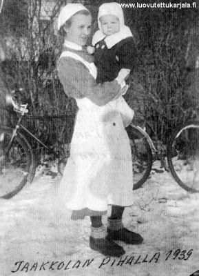 YH: n viestimiesten IV-miesten muonittajana 1939 muonituspäälikkö Anna Raaska kuvassa tyttärensä Ritvan kanssa Jaakkolan pihalla. 
