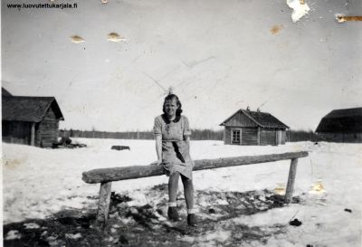 Kuva otettu 1943. Kuvaaja tuntematon. Nainen tuntematon Lunkulansaaren tyttöjä. Kuvan paikka sijaitsee Lunkulansaaren paikassa josta erkanevat tiet saareen Uuksalonpäähän, Mantsinsaarelle, Salmiin, entisen Salmin kunnanjohtajan  Mensolan tilalle ja paikasta 150 m sijaitsi puolustuslinja jossa pysäytettiin venäläisten eteneminen Mantsin saarelle ja Uksalonpäähän. Tältä paikalta suomalaiset suorittivat operaatiot v 1941 saarten valtaamiseksi. 
