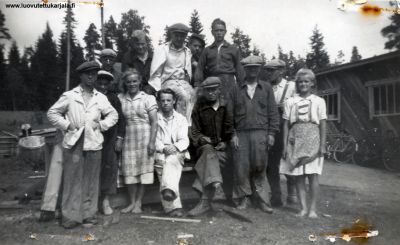 Kuva otettu 1942. Kuvaaja Jukka Saavalainen. Esittävät Puunjalostusliike ja maalausliike N Saavalaisen henkilökuntaa v. 1942. Liike toimi Salmissa vuoteen 1942 ollen alueella monipuoliseen jälleenrakennus toimintaan keskittyvä ehdoton alan asiantuntija liike v. 1944. Liike avakoitiin Savoon Siilinjärvelle, jossa se jatkoi toimintaansa vähäisissä määrin, siirtäen toiminnot lopullisesti Rovaniemelle.
