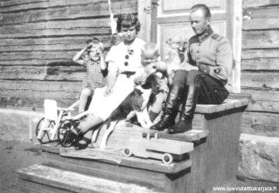 Terijoella v. 1936. Kuvassa lähettäjän äiti Maire Kouhia ja isä Johannes Kouhia sekä veli Raimo ja kuvan lähettäjä. Kuvassa myös perheen koirat Humo ja Hippa.
